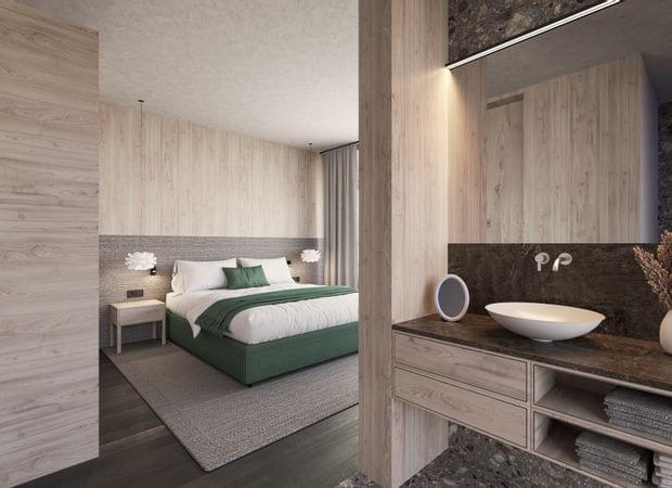 Blick vom Bad ins Schlafzimmer mit Doppelbett in Grün-Weiß, Waschtisch mit runder Schale im Vordergrund