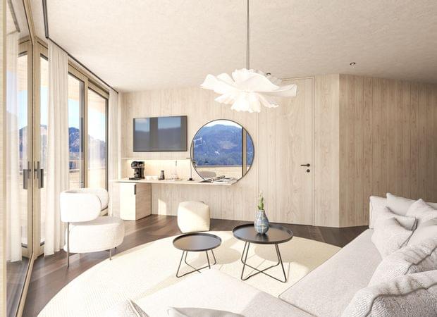 Wohnbereich mit Sofa, rundem Teppich, Couchtischen, Schreibtisch und großem Rundspiegel, dazu Panoramablick