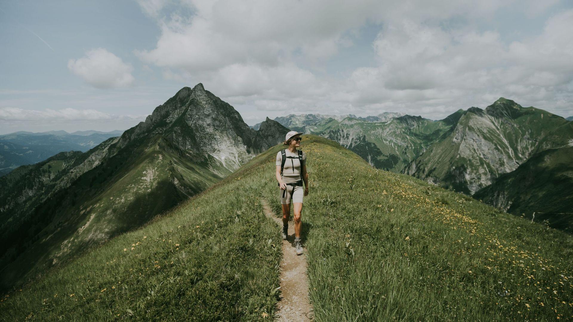 Eine Person wandert auf einem Berggrat beim Wanderurlaub im Allgäu.