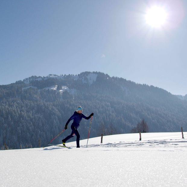 Torghele's Wald + Fluh - Winterurlaub im Allgäu - Frau beim Langlaufen bei Sonnenschein
