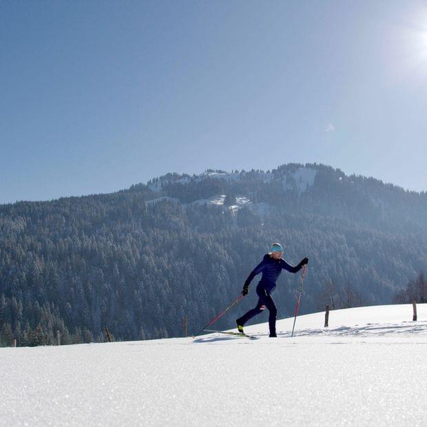 Torghele's Wald + Fluh - Winterurlaub im Allgäu - Frau beim Langlaufen bei Sonnenschein