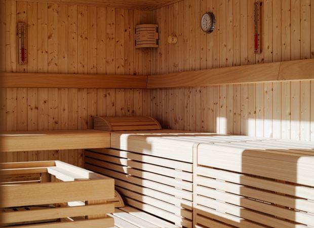 Innenraum einer modernen Holzsauna mit gestuften Holzbänken und warmem Licht.