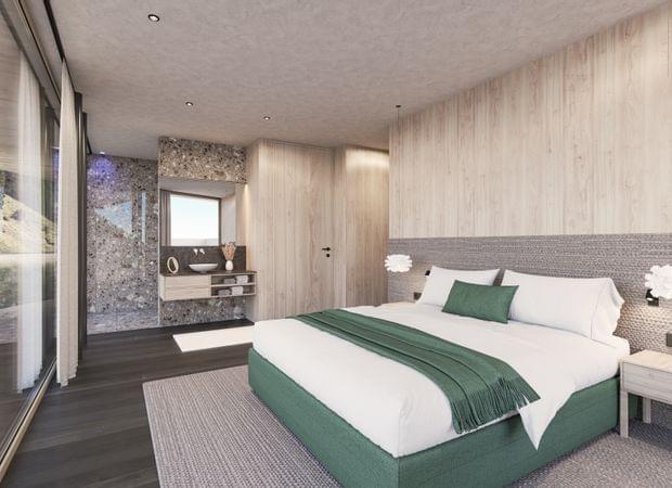 Helles Schlafzimmer mit großem Bett in Grün-Weiß, Holzverkleidung, Nachttischen und Blick ins Bad